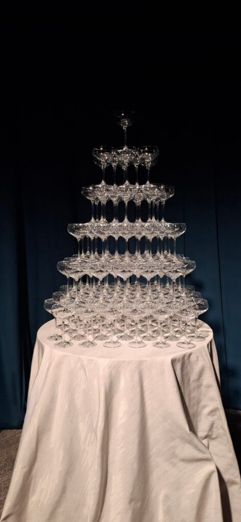 Tiered champagne glass tower prepared for an event celebration.