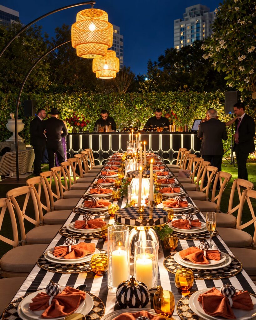 Lanterns and candlelit tables leading to The LiquiNeers bar at an outdoor celebration