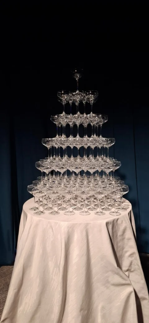 Tiered champagne glass tower prepared for an event celebration.