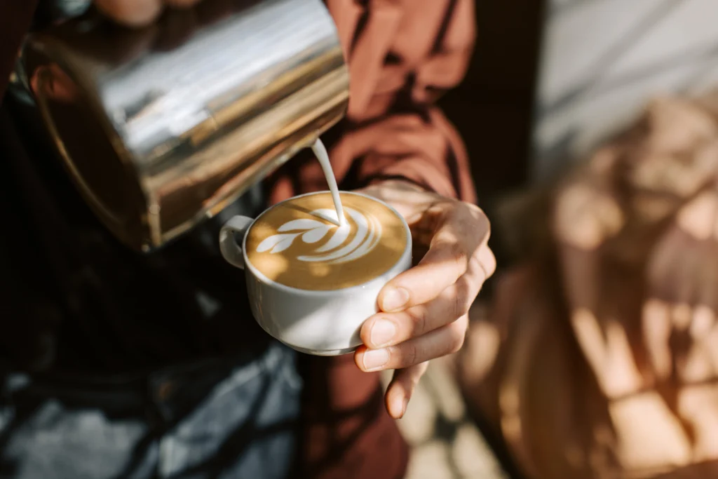 Coffee being poured into a cup during professional barista service.