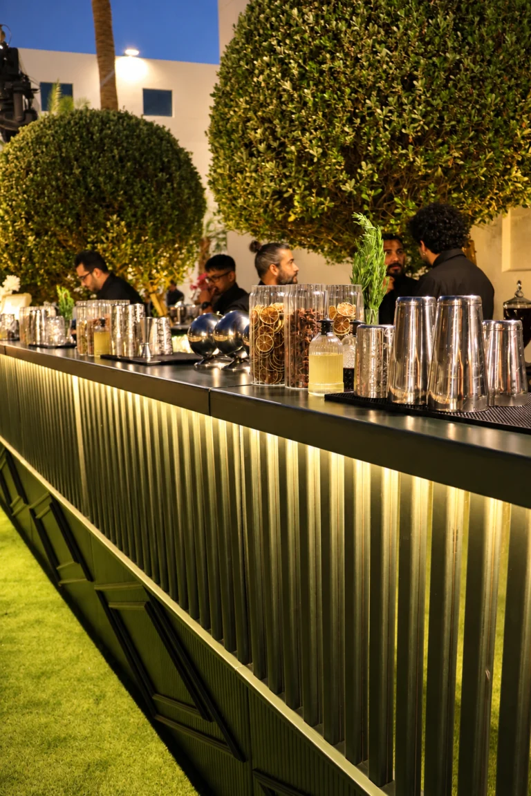 Illuminated Nairobi bar with cocktail shakers, dried citrus garnishes and LiquiNeers mixologists